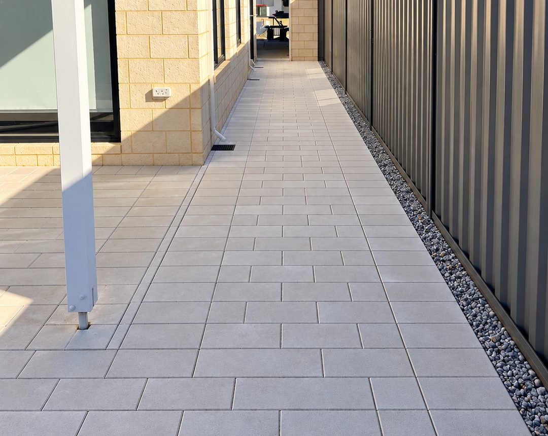Light grey paved side path along a house